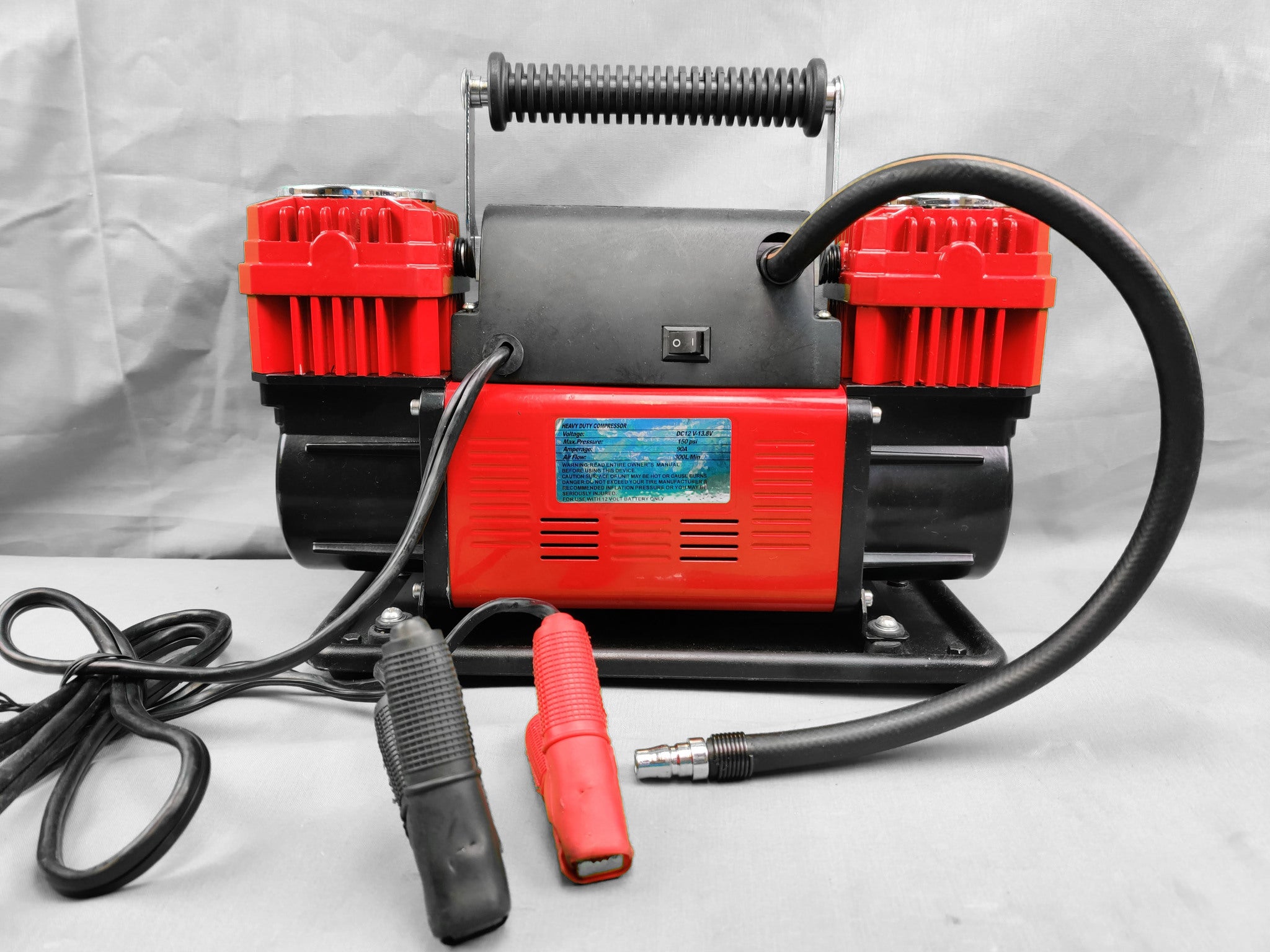 Kantokassilla oleva punainen laadukas kompressori. Mukana kantokassi.